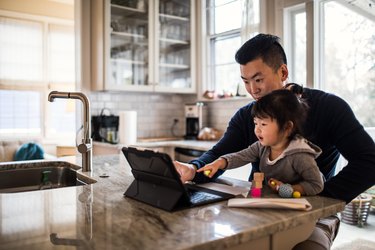 Father working in kitchen with daughter