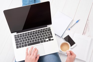 woman  working at home at laptop with  cup of coffee