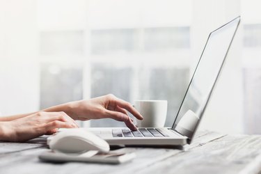 Place of work. Hands on laptop keyboard