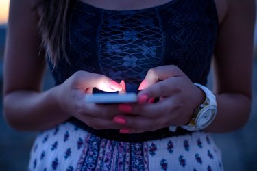 Woman Typing Phone Message On Social Network At Sunset