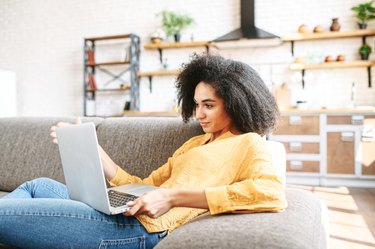 young woman is using laptop at home