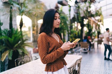 Busy woman texting messages on cellphone