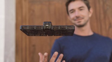 Photo of a man launching the Hover Camera Passport to hover and take photos.