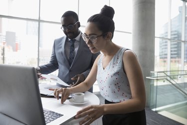 Businessman and businesswoman working at laptop